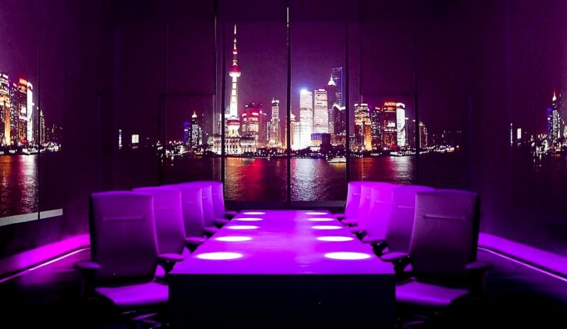 обеденный зал в ресторане Ultraviolet с окнами на город и фиолетовым светом