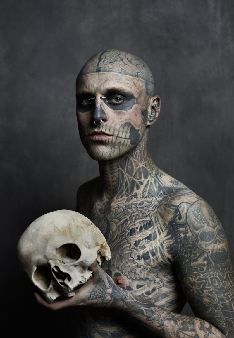 парень с татуировками скелета и черепом в руках