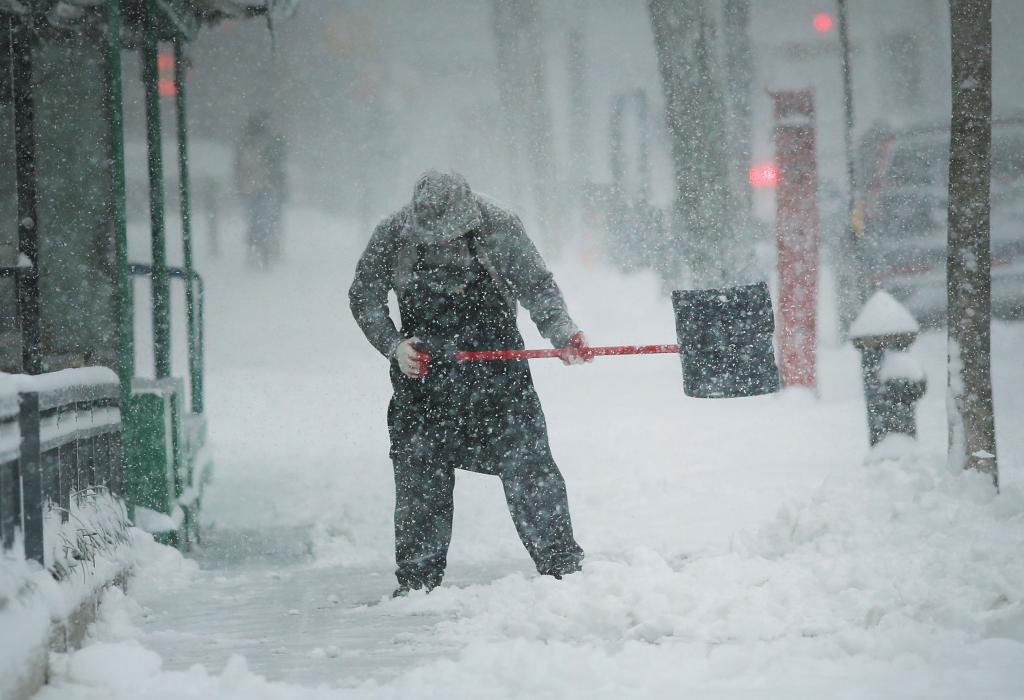Мужчина чистит тротуар от снега