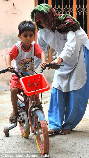 Rajo helps Naveen ride her bicycle