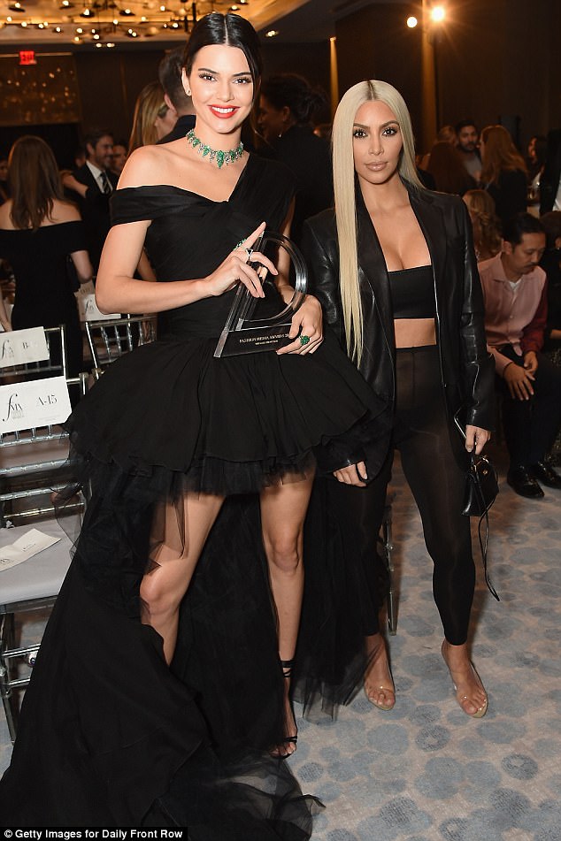 Trendsetter: The mother of two showed off her flat stomach and her ample cleavage in the all-black ensemble; pictured with sister Kendall Jenner