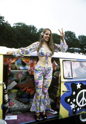 Девушка хиппи стоит в фургоне со знаком пацифист