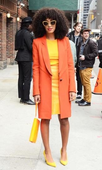 Соланж в оранжевом пальто и желтом платье
