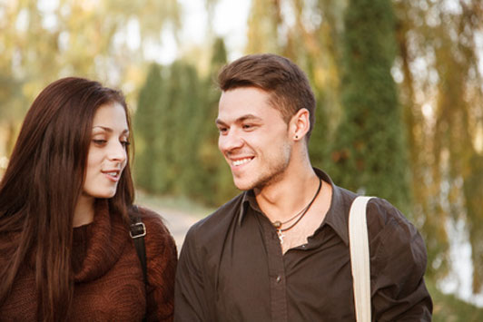 guy walking with girl outdoors smiling