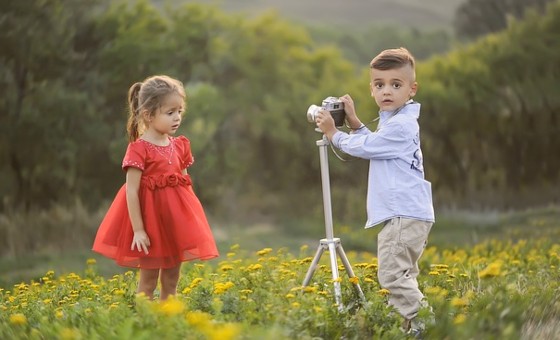 мальчик фотографирует девочку. фото