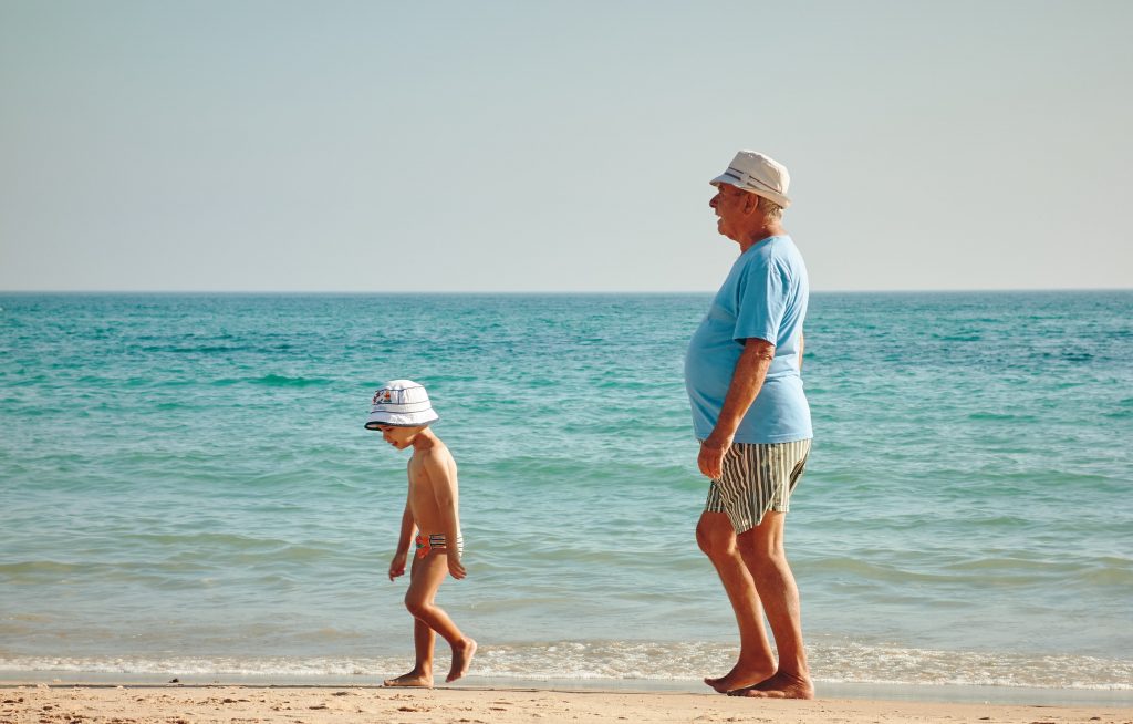 Дедушка и внук идут по пляжу